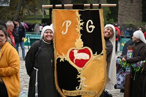 Hermanas sonrientes sosteniendo el escudo de la iglesia